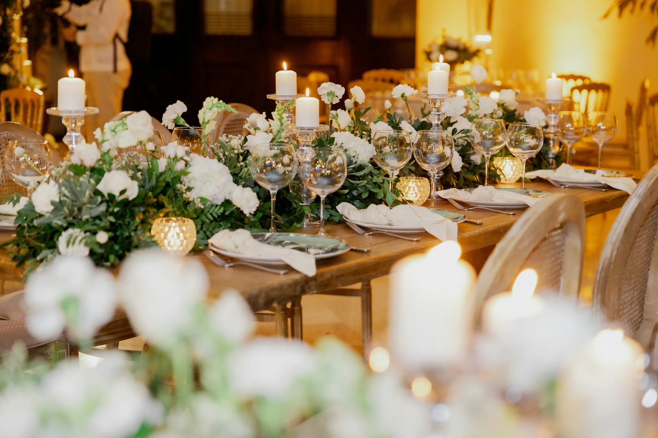 Festlich gedeckte Hochzeitstafel mit weißen Blüten und Kerzenlicht